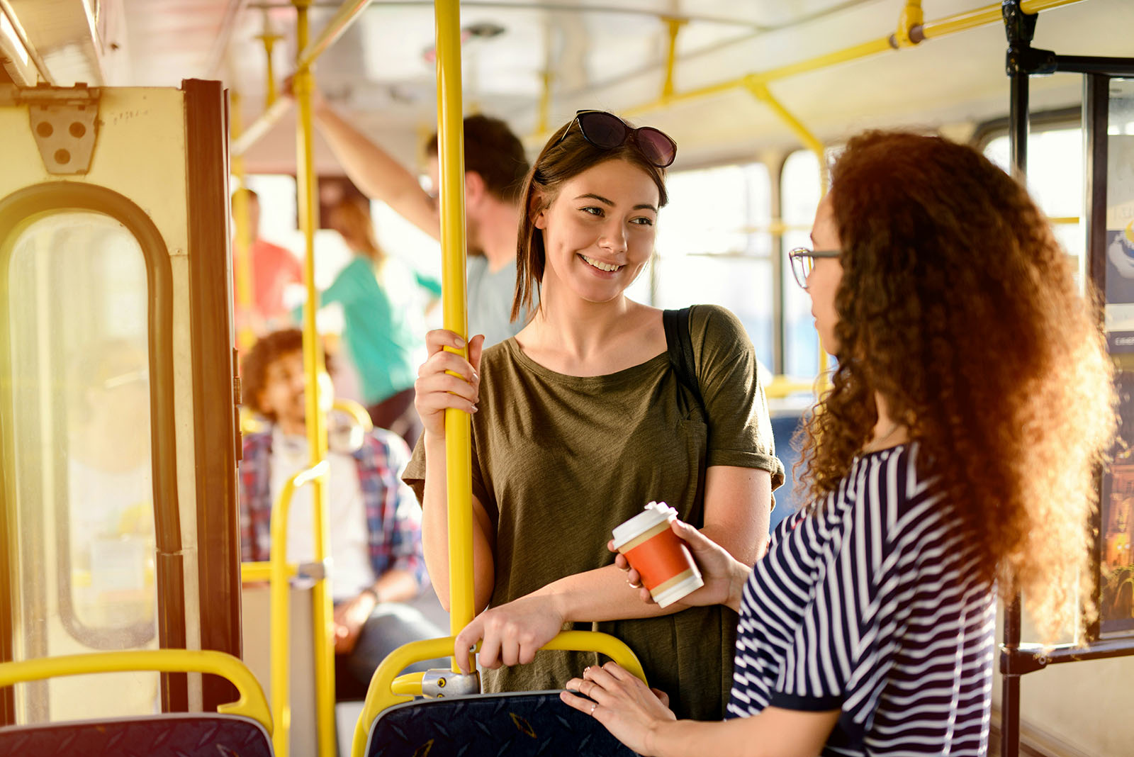 Two people talking in a friendly way on a bus